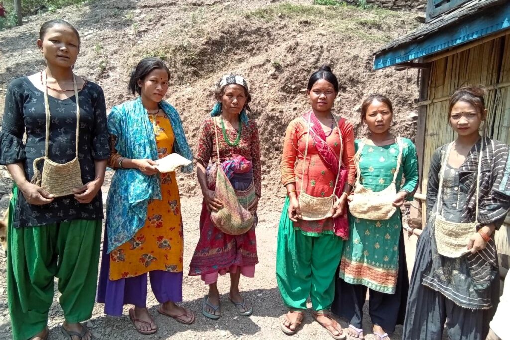 Chepang women in colourful indigenous clothing pose for a photo.