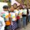 A line of young girls in the Safer Cities for Girls programme show their learning materials.