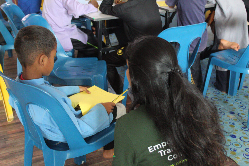 Teacher guides Indigenous Orang Asli student from Kedah, Malaysia.
